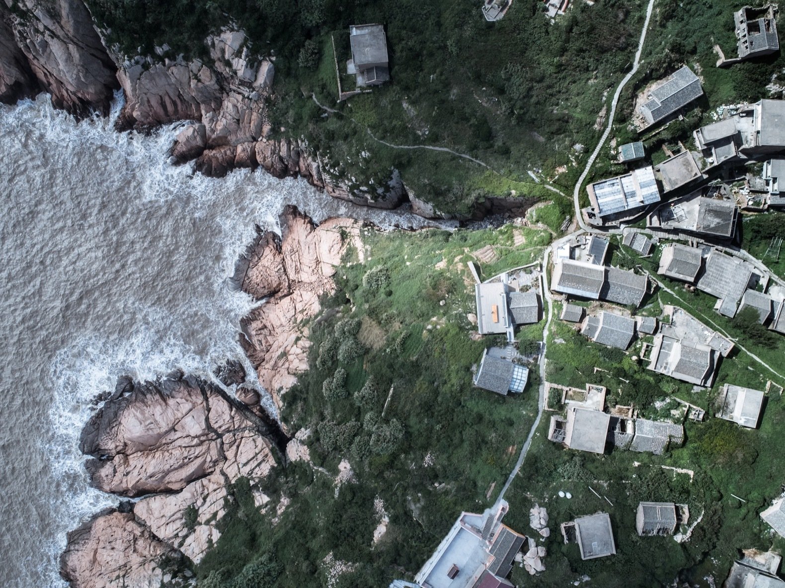 located-on-the-east-side-of-dahuanglong-island-the-buildings-are-set-close-to-the-edge-of-the-weathered-cliffs