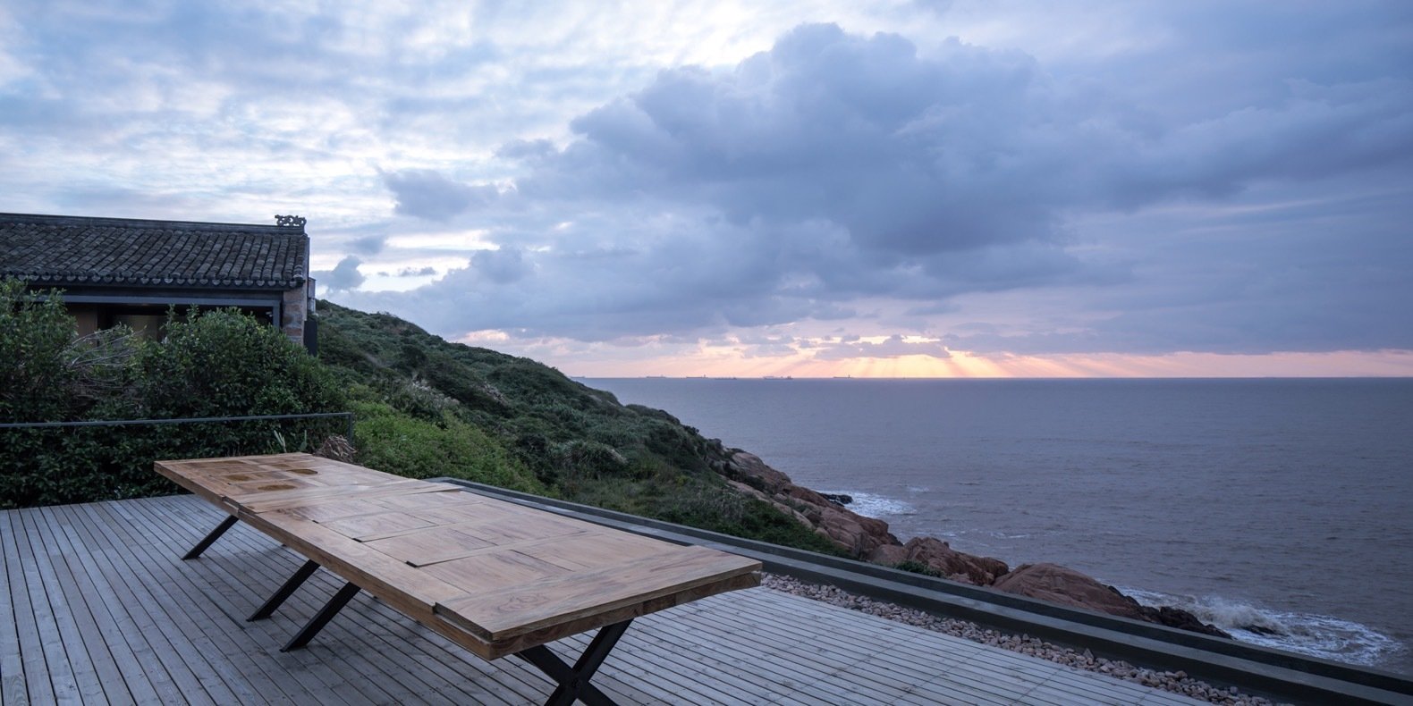 the-wooden-rooftop-deck-is-edged-with-river-stone