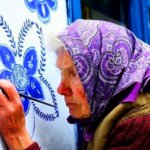 סבתא צ'כית בת 93, מעטרת בפרחים מצוירים את בתי שכניה בכפר