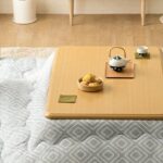 היפנים יושבים מסביב לשולחנות Kotatsu מחוממים, המשולבים בשמיכה, כדי לשרוד את הקור