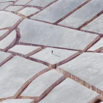 אמן כיסה עיר שנהרסה, במשטח בטון מלא בסדקים